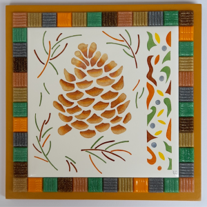 Photo de la décoration murale "Pomme de pin", carreau de céramique représentant une pomme de pin aux couleurs de l'automne peint à la main